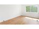 Sunlit bedroom featuring hardwood floors and white walls with a window to the green trees at 2873 Bob White Sw Dr, Atlanta, GA 30311