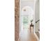 Bright hallway featuring a brick accent wall, white door and arched doorway for a modern yet rustic aesthetic at 2873 Bob White Sw Dr, Atlanta, GA 30311