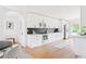 Modern kitchen with white cabinets, stainless steel appliances, sleek black backsplash and adjacent dining area at 2873 Bob White Sw Dr, Atlanta, GA 30311