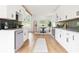 Modern kitchen with white cabinets, black backsplash, stainless steel appliances, and an adjacent dining area at 2873 Bob White Sw Dr, Atlanta, GA 30311