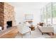 Spacious living room with a brick fireplace, large windows, and neutral-toned furniture for a comfortable atmosphere at 2873 Bob White Sw Dr, Atlanta, GA 30311