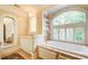 Bright bathroom with a soaking tub, large window, white cabinets, and neutral tile at 42 Greenland Trce, Atlanta, GA 30342