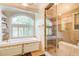 A luxury bathroom with a soaking tub, glass shower with tile surround and large window at 42 Greenland Trce, Atlanta, GA 30342