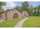 Charming brick home featuring unique arched doorways and mature landscaping on a sprawling green lawn at 4296 Linda Sw Ln, Lilburn, GA 30047