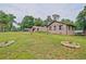 Wide angle view of a brick home with a large, well-maintained lawn and mature trees in the background at 4296 Linda Sw Ln, Lilburn, GA 30047