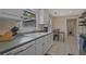 Functional kitchen with white cabinetry, tile flooring, and a window view of the backyard at 4296 Linda Sw Ln, Lilburn, GA 30047