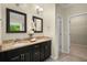 Bathroom featuring a dual sink vanity with granite countertop and dark wood cabinets at 830 Nottingham Se Dr, Smyrna, GA 30082