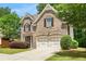 Two-story brick home featuring an attached two-car garage, inviting curb appeal, and mature landscaping at 830 Nottingham Se Dr, Smyrna, GA 30082