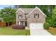 Charming two-story brick home featuring a well-manicured lawn and attached two-car garage at 830 Nottingham Se Dr, Smyrna, GA 30082