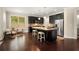 Open-concept kitchen with dark cabinets, granite island, stainless steel appliances, and hardwood floors at 830 Nottingham Se Dr, Smyrna, GA 30082