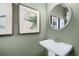 Stylish half bath features a pedestal sink, modern faucet and framed artwork at 1095 Elowen Dr, Austell, GA 30168