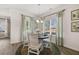 Bright dining area with a round table, white chairs, and a chandelier near a window with leafy patterned curtains at 1095 Elowen Dr, Austell, GA 30168