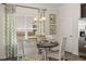 Bright dining area with a round table, white chairs, and a chandelier near a window with leafy patterned curtains at 1095 Elowen Dr, Austell, GA 30168