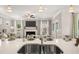 Spacious kitchen island with seating, stainless steel sink, and a view into the living room with a fireplace at 1095 Elowen Dr, Austell, GA 30168