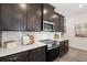Well-lit kitchen with a sleek stovetop, microwave, white backsplash and dark wood cabinets at 1095 Elowen Dr, Austell, GA 30168