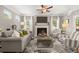 Cozy living room with a fireplace, neutral-toned furniture, and lots of natural light from large windows at 1095 Elowen Dr, Austell, GA 30168