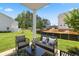 Outdoor patio with stylish wicker furniture, overlooking a grassy backyard and wooded area at 1095 Elowen Dr, Austell, GA 30168