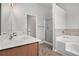 Bright bathroom featuring double sink vanity, tiled floors, soaking tub, and walk-in shower at 5152 Rapahoe Trl, Atlanta, GA 30349