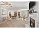 Expansive open-concept living room featuring a cozy fireplace, archways to the kitchen, and a ceiling fan for added comfort at 5152 Rapahoe Trl, Atlanta, GA 30349