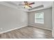 Bedroom with tray ceiling, fan, and light gray walls with a window providing natural light at 7262 Sandpiper Way, Riverdale, GA 30274