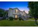 Inviting two-story home with manicured lawn, illuminated landscaping, gray stairs, and two-car garage at 7262 Sandpiper Way, Riverdale, GA 30274