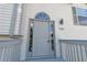 Charming gray front door with decorative window and sidelights, nestled within a light beige facade at 7262 Sandpiper Way, Riverdale, GA 30274
