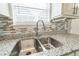Close-up view of the kitchen sink, granite countertops, and stylish backsplash at 7262 Sandpiper Way, Riverdale, GA 30274