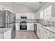 Bright kitchen featuring stainless steel appliances, granite countertops, and white cabinetry at 7262 Sandpiper Way, Riverdale, GA 30274