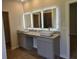 Bathroom with double vanity with vessel sinks, granite counters, and illuminated mirrors at 1661 Fuma Leaf Way, Mcdonough, GA 30253