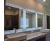 Modern bathroom features dual sinks, granite countertop, and well-lit vanity mirrors at 1661 Fuma Leaf Way, Mcdonough, GA 30253