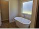 Soaking tub with a large window providing natural light at 1661 Fuma Leaf Way, Mcdonough, GA 30253