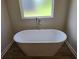 Freestanding tub with modern fixtures and frosted window for privacy at 1661 Fuma Leaf Way, Mcdonough, GA 30253