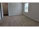 A bright carpeted bedroom features a window and an attached walk-in closet at 1661 Fuma Leaf Way, Mcdonough, GA 30253