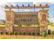 Stone and brick community entrance sign with lush landscaping and clear signage at 1661 Fuma Leaf Way, Mcdonough, GA 30253