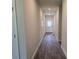 Hallway with LVP flooring and access to the front door and secondary rooms at 1661 Fuma Leaf Way, Mcdonough, GA 30253