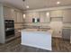 Kitchen area showcasing gray cabinets, an island, granite counters, and stainless steel appliances at 1661 Fuma Leaf Way, Mcdonough, GA 30253