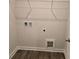 A cozy laundry room features wood-look vinyl flooring and utility connections at 1661 Fuma Leaf Way, Mcdonough, GA 30253