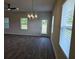 Open living room featuring LVP flooring, multiple windows for natural light, and modern lighting at 1661 Fuma Leaf Way, Mcdonough, GA 30253