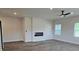 This living room is spacious and well-lit with a modern fireplace, and a ceiling fan at 1661 Fuma Leaf Way, Mcdonough, GA 30253