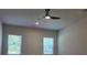 Living room with a ceiling fan and two windows providing natural light at 1661 Fuma Leaf Way, Mcdonough, GA 30253