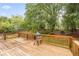 Inviting wooden back deck with a grill and surrounded by lush greenery, creating a serene outdoor space at 4960 Haydens Walk Dr, Johns Creek, GA 30022