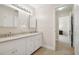 Bathroom featuring dual sinks and a tile floor, leading to a connecting hall at 4960 Haydens Walk Dr, Johns Creek, GA 30022