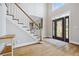 Light-filled foyer featuring hardwood floors, staircase, and decorative glass front door at 4960 Haydens Walk Dr, Johns Creek, GA 30022