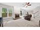 Spacious living room featuring a brick fireplace, large windows, and a ceiling fan at 4960 Haydens Walk Dr, Johns Creek, GA 30022