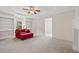 Sitting room with a red chaise lounge, wall of built-in shelves and an adjacent fireplace at 4960 Haydens Walk Dr, Johns Creek, GA 30022