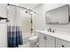 Updated bathroom featuring a shower-tub combo, white vanity, and a framed mirror at 500 Gardenia Ln, Marietta, GA 30068