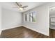 A bright bedroom with wood flooring, a ceiling fan, and a window overlooking the backyard at 500 Gardenia Ln, Marietta, GA 30068