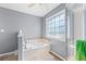 Bright bathroom featuring a soaking tub and separate glass shower with a window at 850 Long Branch Cir, Sugar Hill, GA 30518