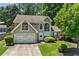 Charming home with a manicured lawn, two-car garage, and mature trees offering curb appeal at 850 Long Branch Cir, Sugar Hill, GA 30518
