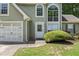Inviting front entrance with well-maintained landscaping, a two-car garage, and manicured lawn at 850 Long Branch Cir, Sugar Hill, GA 30518